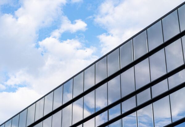 Modern Glass Building Architecture with blue sky and clouds